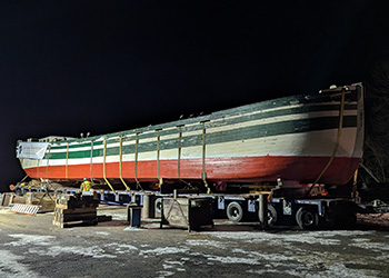 Lois McClure lifted onto trailer for final move